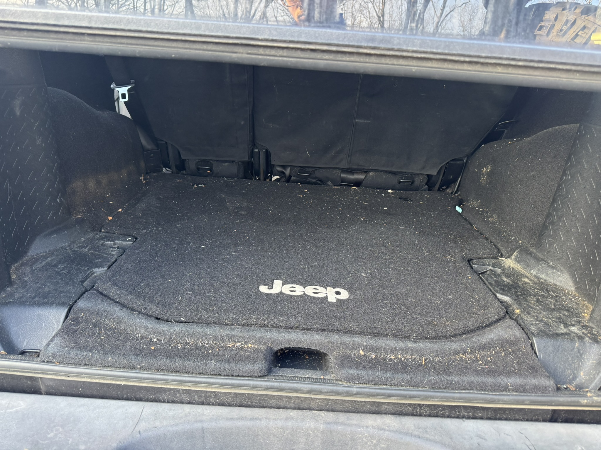 Before: dirty Jeep cargo area with debris